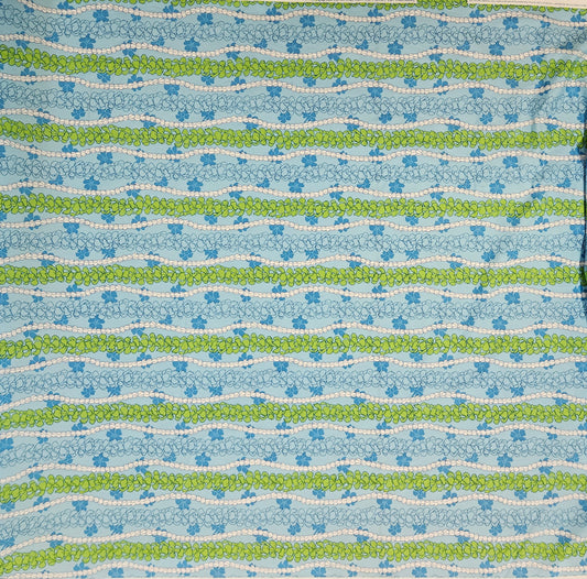 Patterned fabric with blue, green, and white floral stripes on a blue background