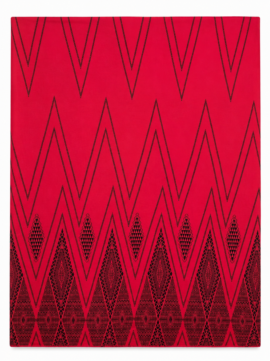 Red rug with black geometric pattern on a white background