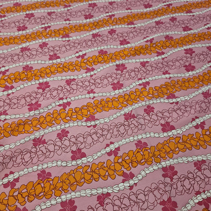 Patterned fabric with orange, white, and pink floral design on a pink background