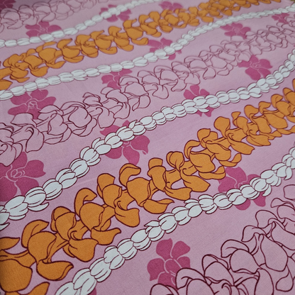Decorative fabric with floral and braid patterns on a pink background