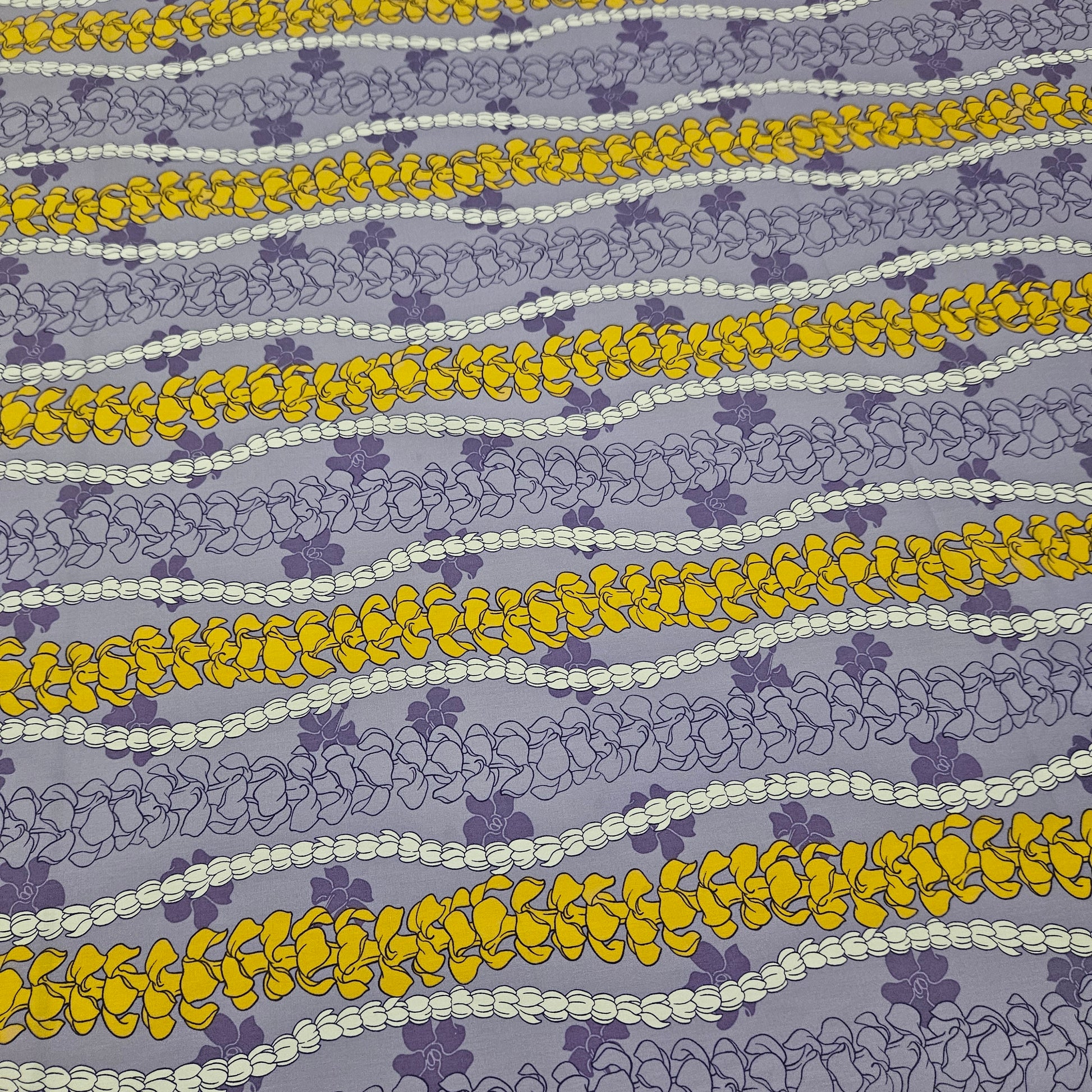 Patterned fabric with yellow and white floral designs on a purple background