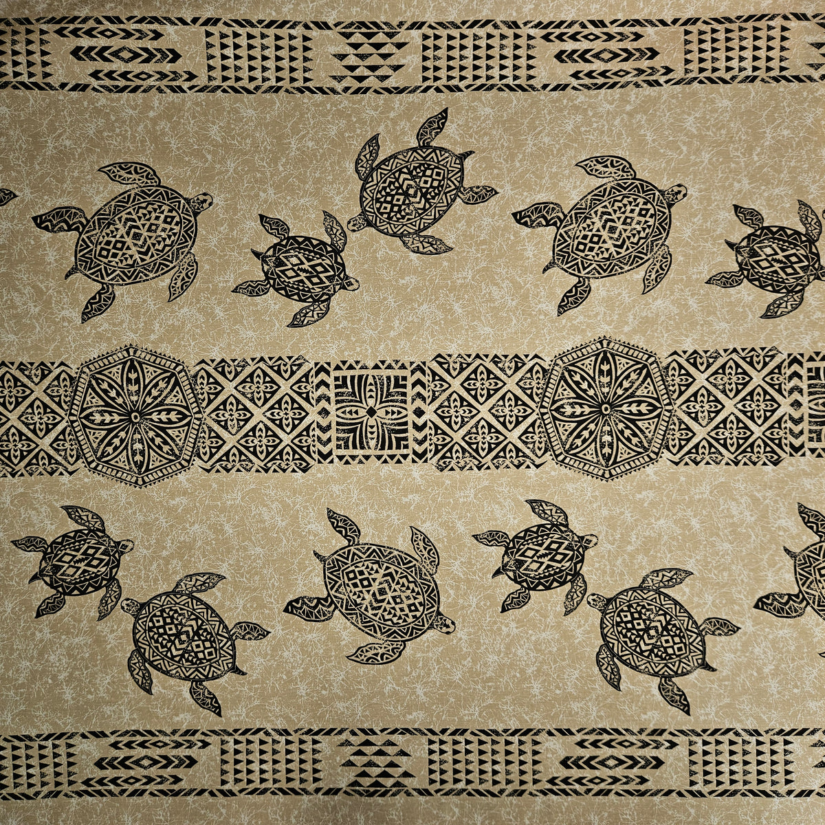 Patterned fabric with turtles and tribal designs on a beige background
