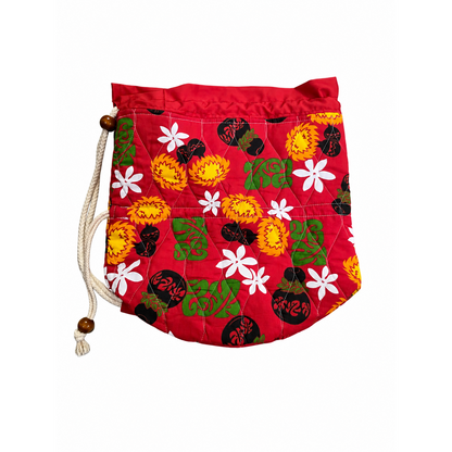 A red quilted drawstring bag with a print showing images of tiares, ipus, and uliuli.