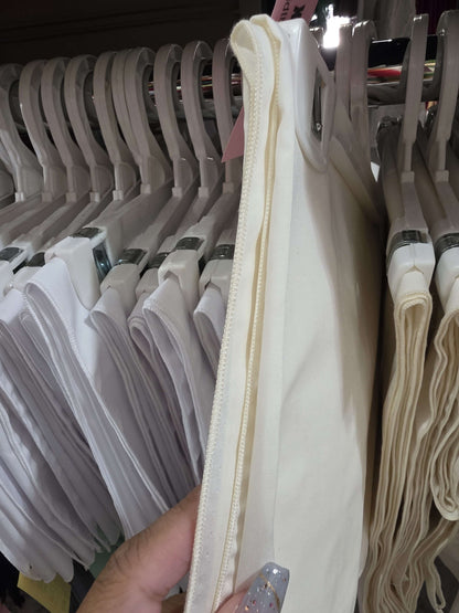 White fabric on a hanger with a blurred background of similar items.
